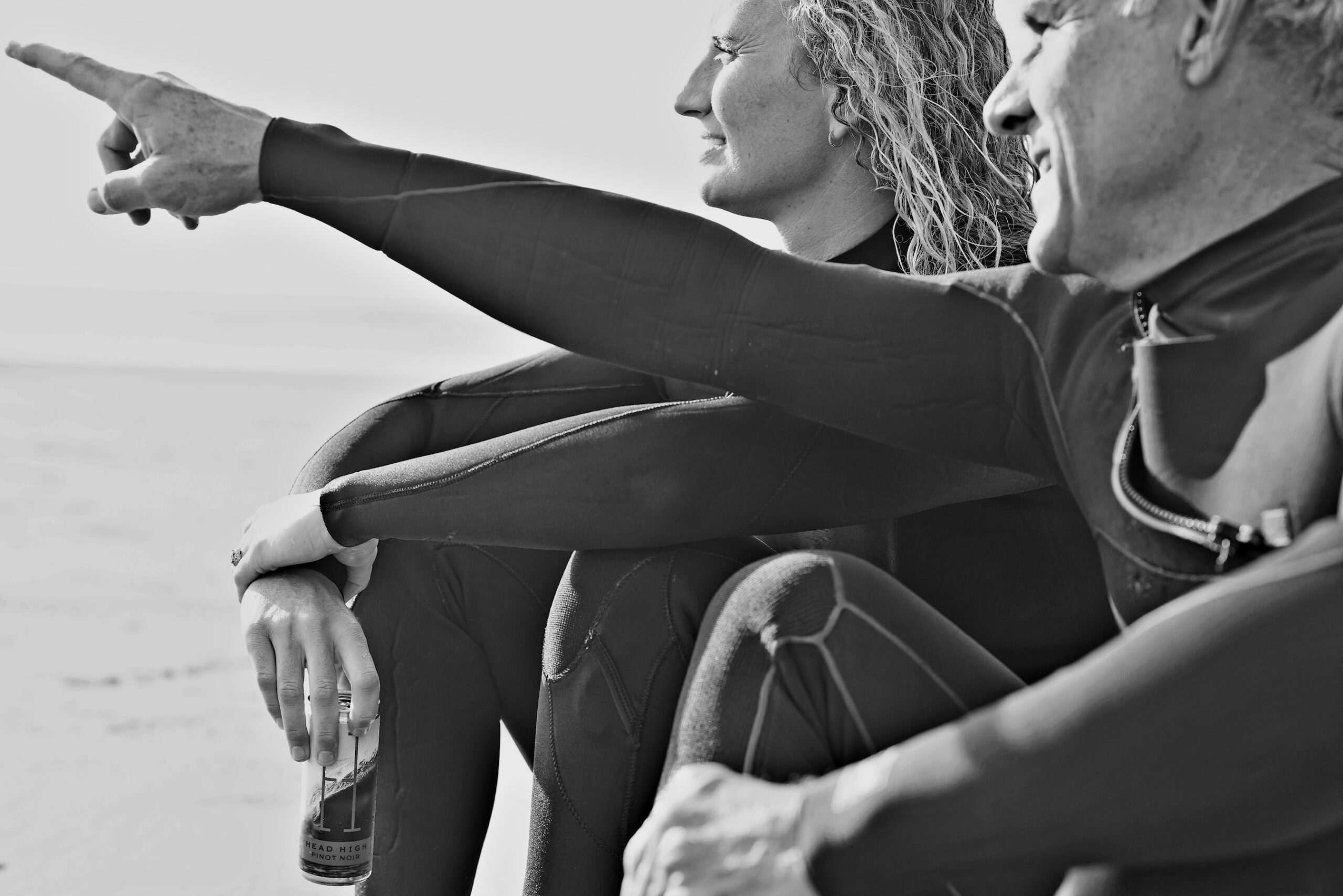 2 surfers pointing to the distance