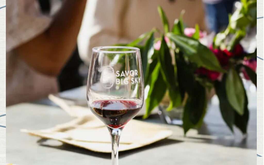 Red wine glass with plant in background