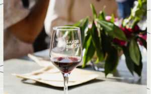 Red wine glass with plant in background