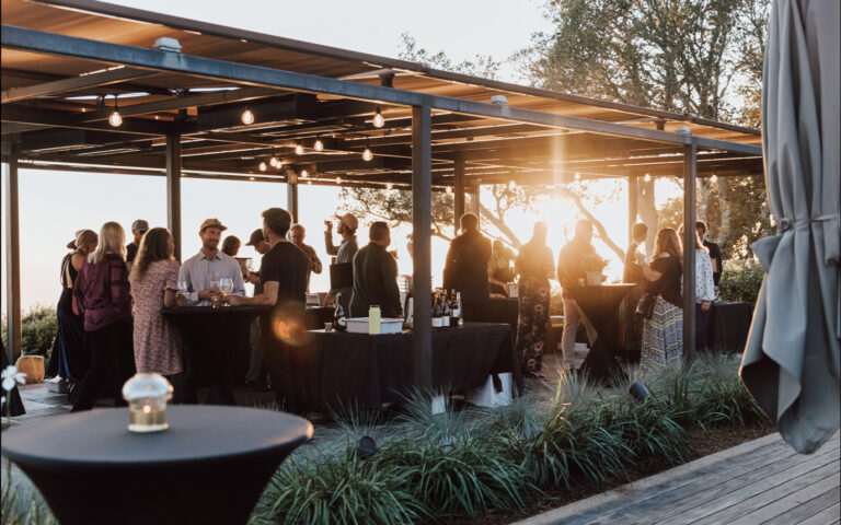 Happy people enjoying wine at sunset on a patio