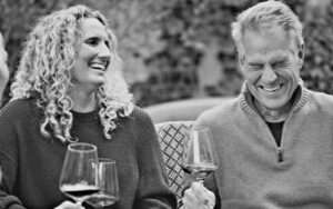 Girl and man laughing with wine in black and white photo